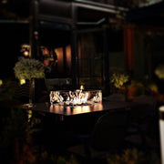 Mesa de Fuego Exterior – Elegancia y Función para tu Jardín — de noche, con llama encendida
