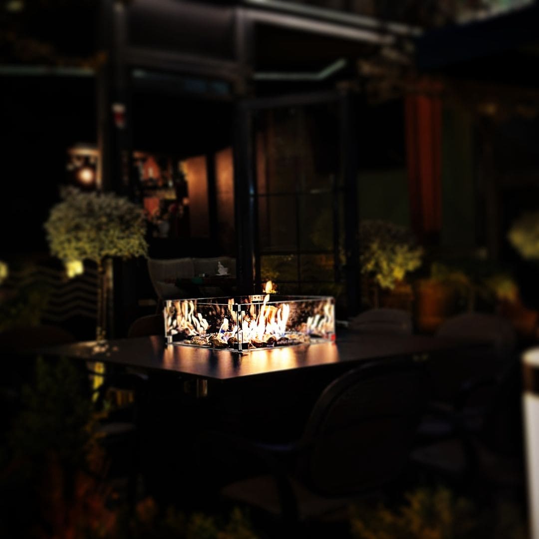 Mesa de Fuego Exterior – Elegancia y Función para tu Jardín — de noche, con llama encendida