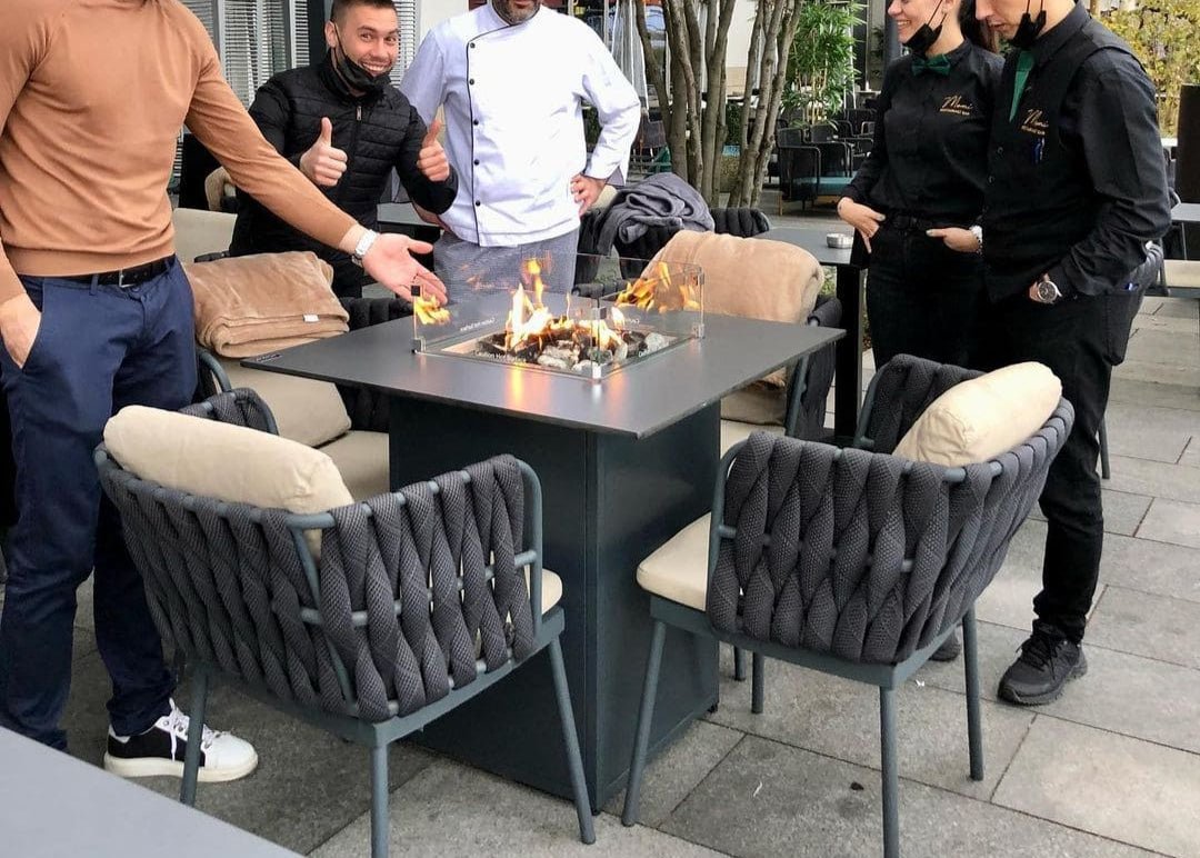 Mesa de Fuego Exterior – Elegancia y Función para tu Jardín — en restaurante, con llama encendida